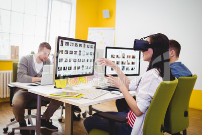 Executive enjoying augmented reality headset with colleagues at creative office