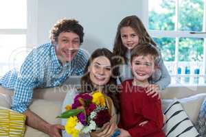 Portrait of happy family with flower bouquet