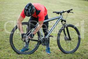 Male mountain biker fixing his bike chain