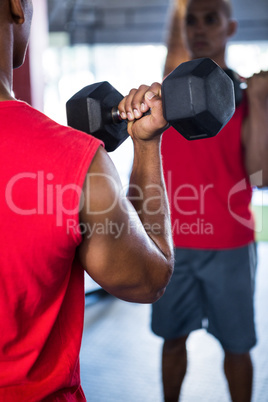 Reflection of man exercising with dumbbells
