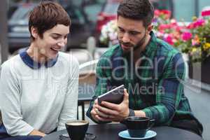 Businesspeople using digital tablet while having coffee