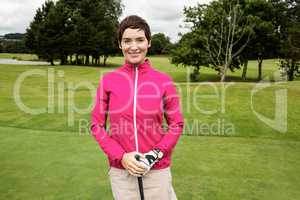 Woman standing with golf club in golf course