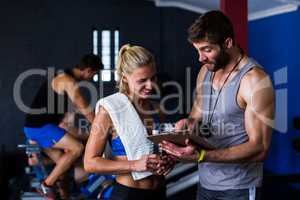 Fitness instructor discussing with woman in gym