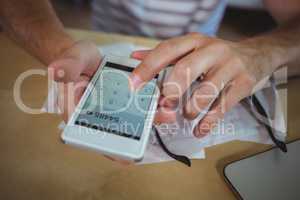Man calculating bills on mobile phone