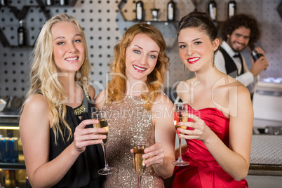 Three smiling friend having glass of champagne