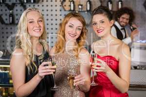 Three smiling friend having glass of champagne