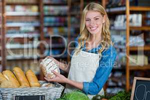 Smiling staff holding bread in organic section