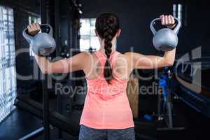 Rear view of athlete holding kettlebell in gym