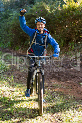 Portrait of excited male mountain biker in the forest