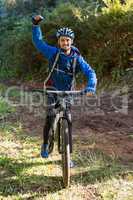Portrait of excited male mountain biker in the forest
