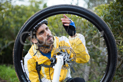 Male biker repairing mountain bike