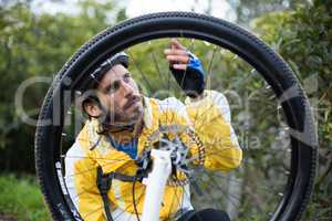 Male biker repairing mountain bike