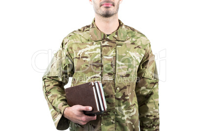 Mid section of soldier holding books
