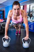 Portrait of serious female athlete doing push-ups