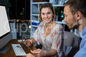 Businesswoman discussing with colleague over digital tablet