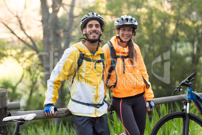 Biker couple standing in countryside forest