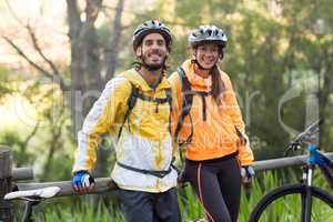 Biker couple standing in countryside forest