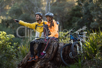 Biker couple sitting and pointing in distance