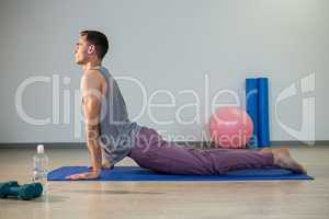 Man doing cobra pose on exercise mat