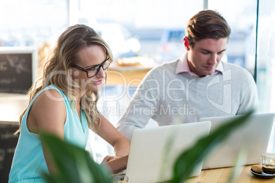 Man and woman using laptop during meeting