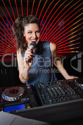 Pretty female DJ playing music