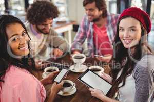Group of friends using digital tablet and mobile phone