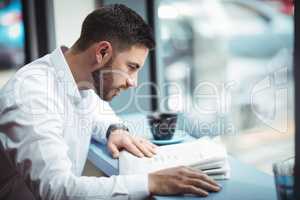 Businessman reading newspaper in office