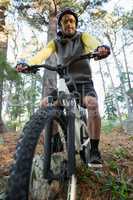 Portrait of male mountain biker riding bicycle in the forest