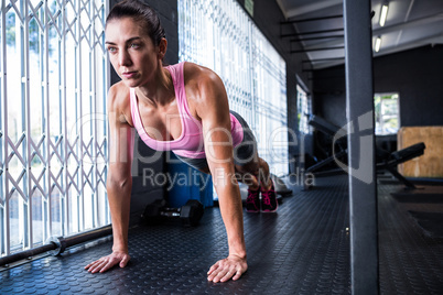 Full length of young female athlete doing push-ups