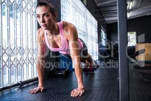 Full length of young female athlete doing push-ups