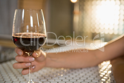 Woman having red wine at bar counter