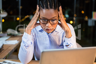 Stressed businesswoman sitting at her desk