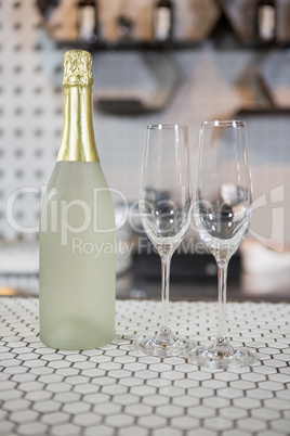 Champagne bottle and champagne flute on bar counter