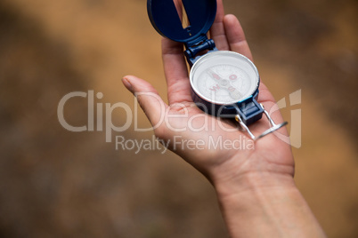 Hand holding compass in forest