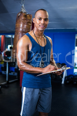 Male trainer with clipboard in gym