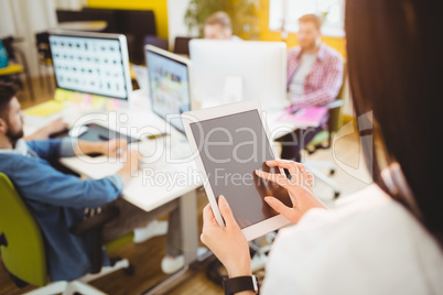 Rear view of executive using digital tablet at creative office