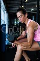 Side view of female athlete lifting dumbbell