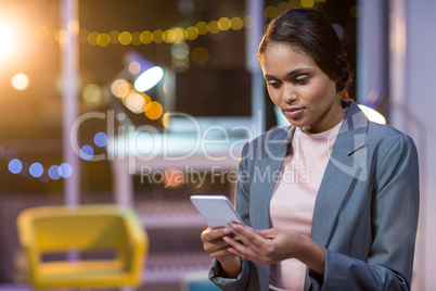 Businesswoman text messaging on mobile phone