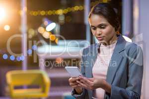 Businesswoman text messaging on mobile phone