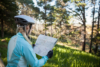 Female mountain biker looking at map