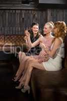 Three female friends having tequila in bar