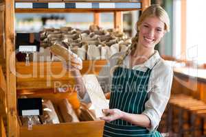 Female staff packing a bread in paper bag