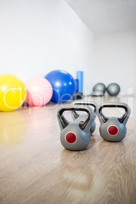 Three grey kettlebell on wooden floor