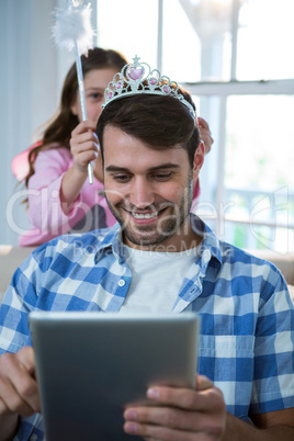 Girl dressed up in a fairy costume placing tiara on fathers head