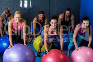 Athletes smiling while exercising on fitness ball