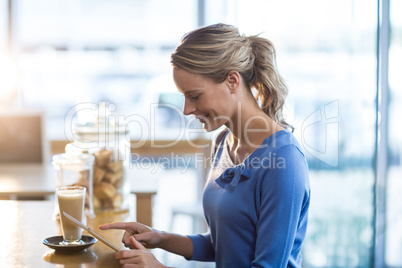 Smiling woman using digital tablet in cafÃ?Â©