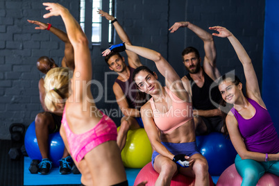 Athletes exercising with instructor in gym