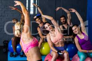 Athletes exercising with instructor in gym