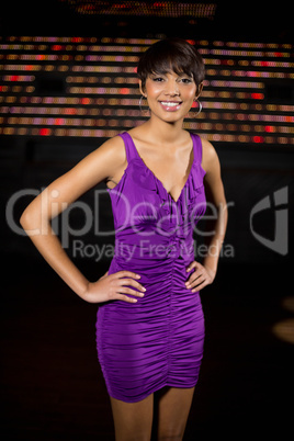 Portrait of young woman standing with hand on hip