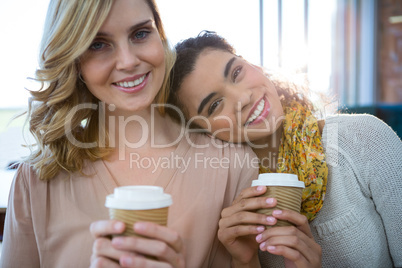Portrait of female friends sitting together and having coffee